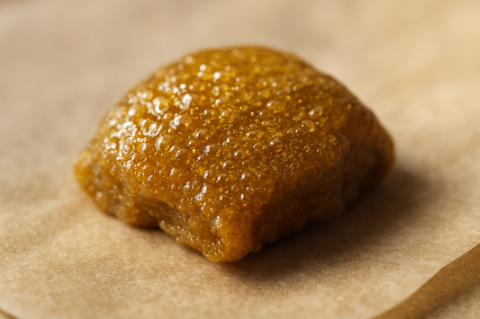 Makroaufnahme eines goldenen Stücks Bubble Hash auf Backpapier, Fokus-Keyword Bubble Hash.