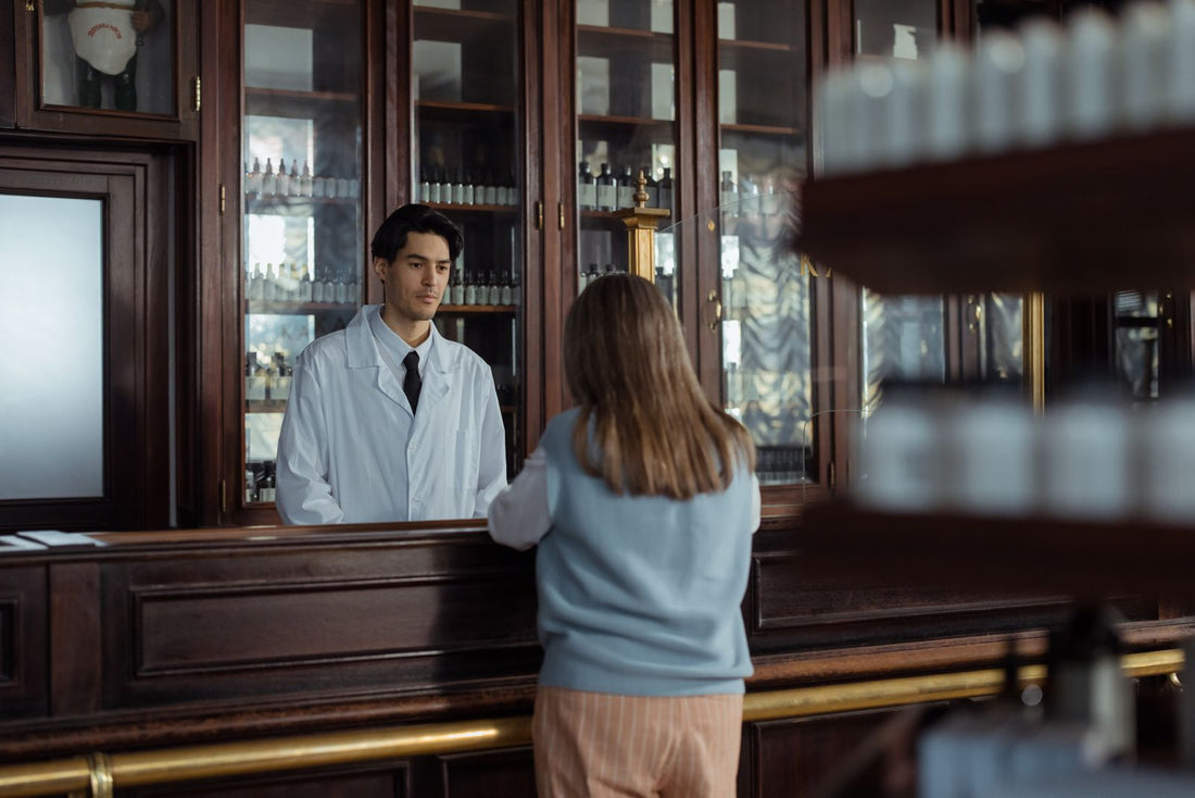 Apotheker berät eine Kundin am Tresen, Symbolbild für Cannabis aus der Apotheke